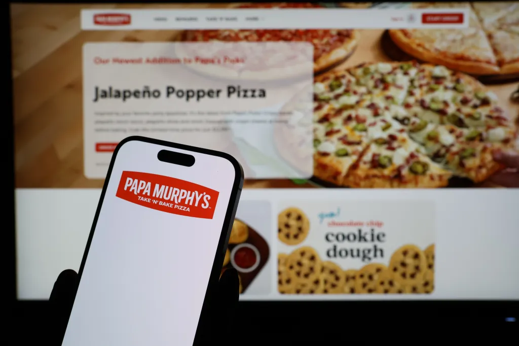 A smartphone displaying the Papa Murphy's logo in front of the company's webpage, which features a Jalapeño Popper Pizza.