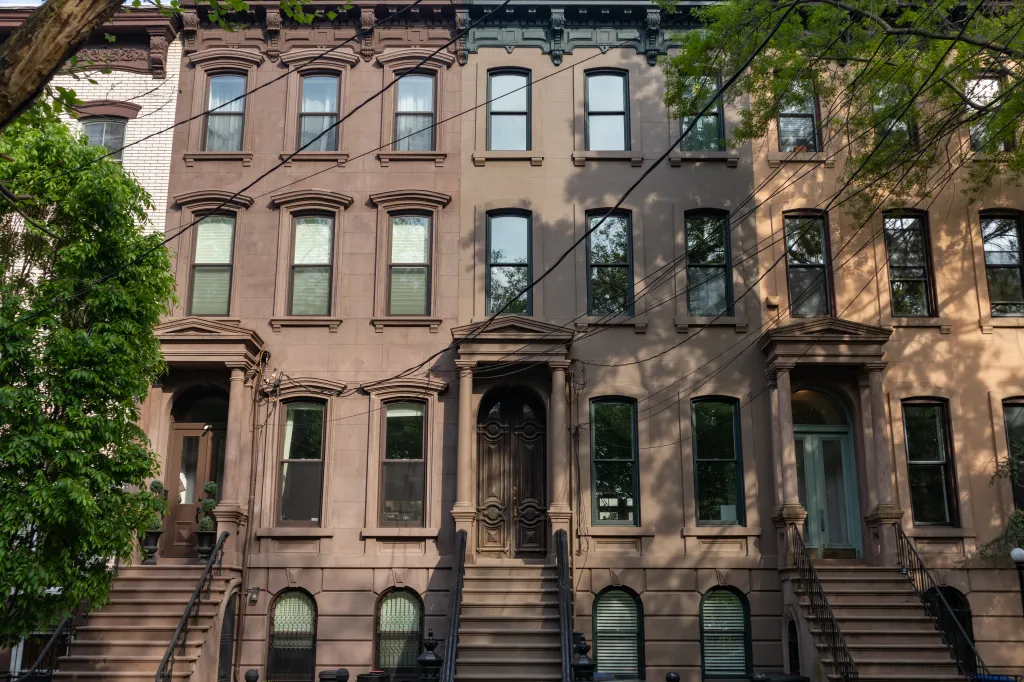Row of beautiful old connecting brownstone homes with staircases in Jersey City, New Jersey.