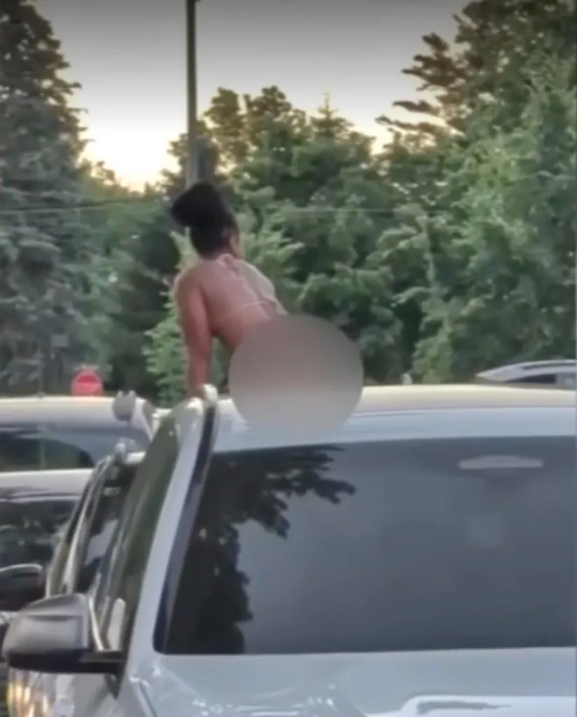 Woman in a bikini on top of a car.