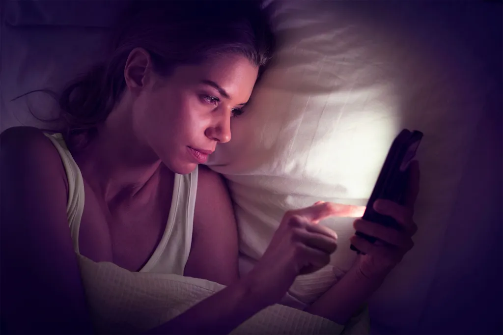 Young woman using a digital tablet in bed.