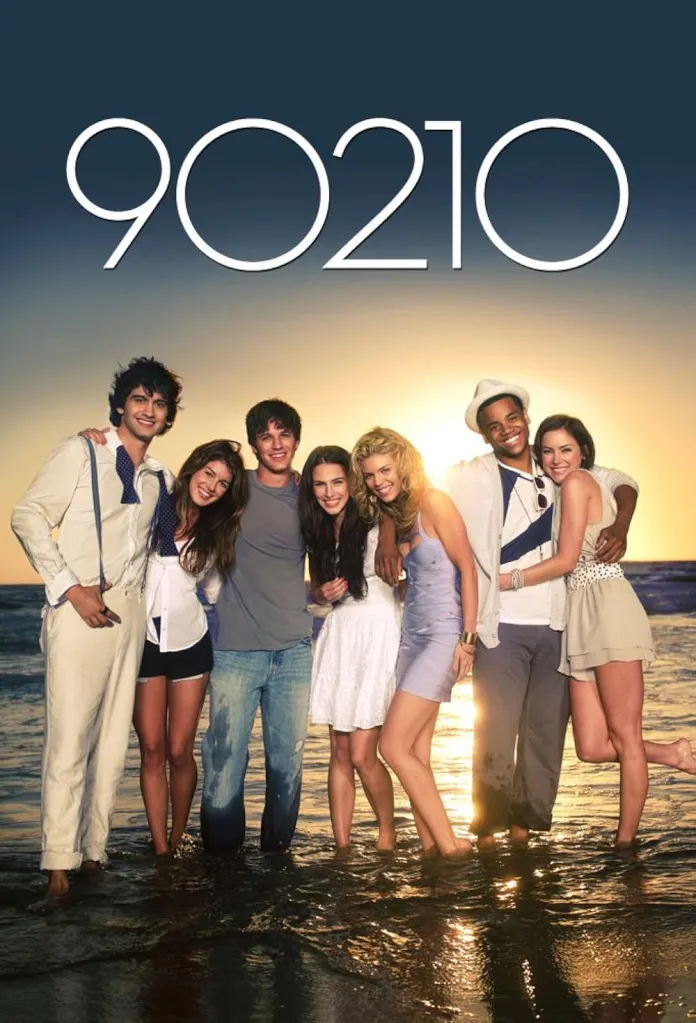 The cast of 90210 standing in the ocean at sunset.