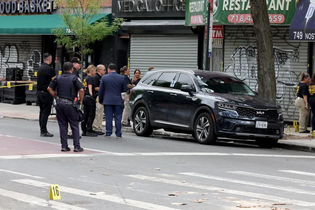 NYPD Crime Scene Unit detectives examine a police vehicle struck by gunfire near Nostrand Avenue and St. Johns Place in Crown Heights, Brooklyn.