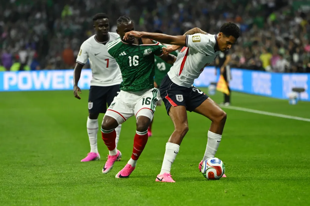 Julian Quiñones (Mexico) and Jarell Quansah (England) battle for the ball during a FIFA World Cup 2026 match.