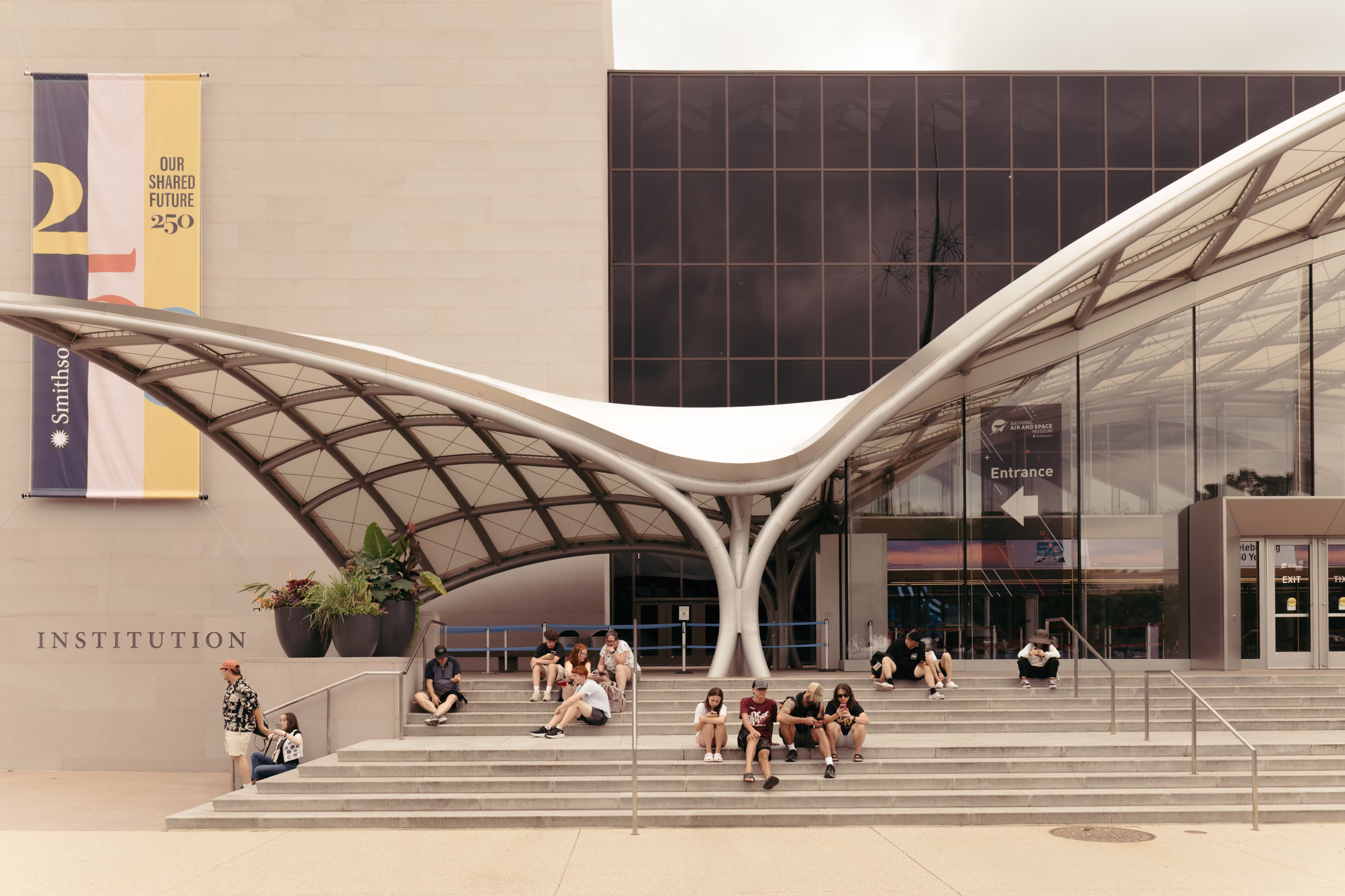 people sit outside of a museum