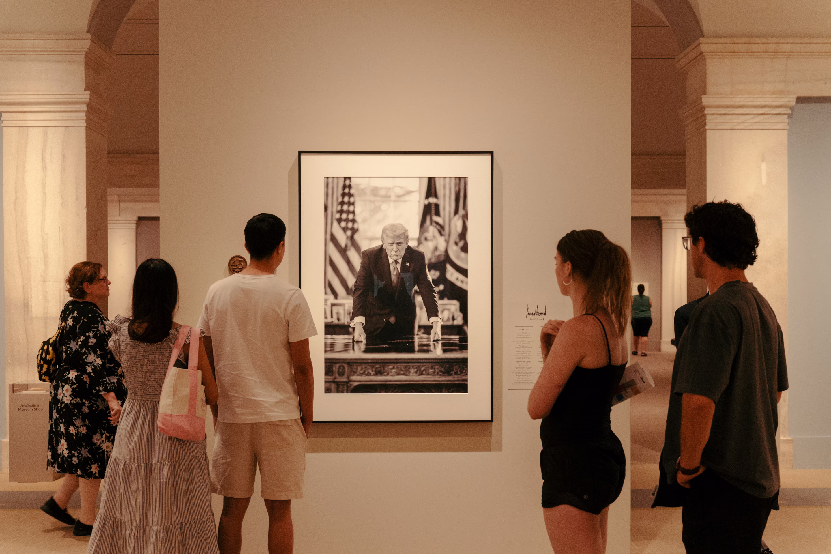 people look at a framed photo of Donald Trump