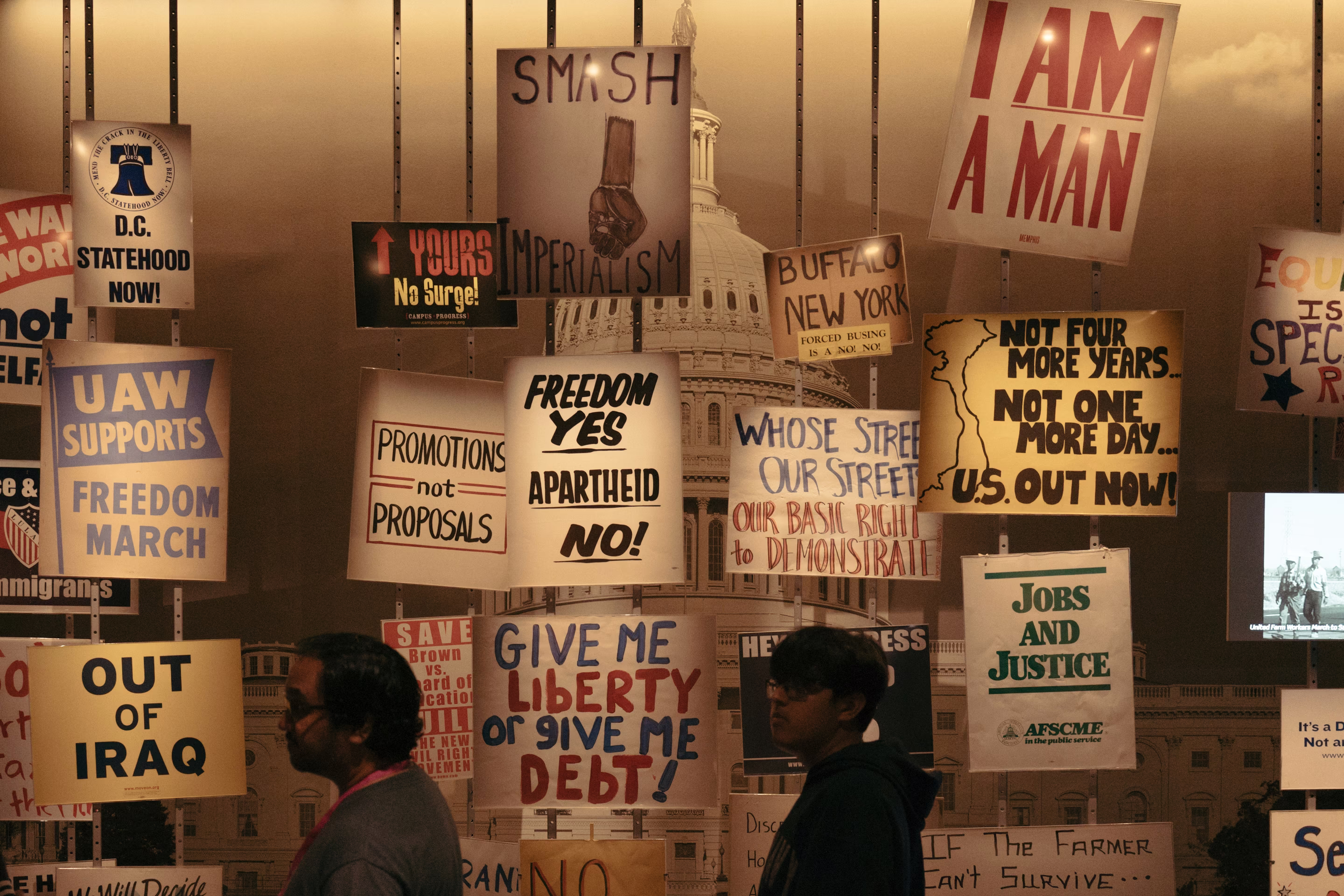 People walk past protest signs