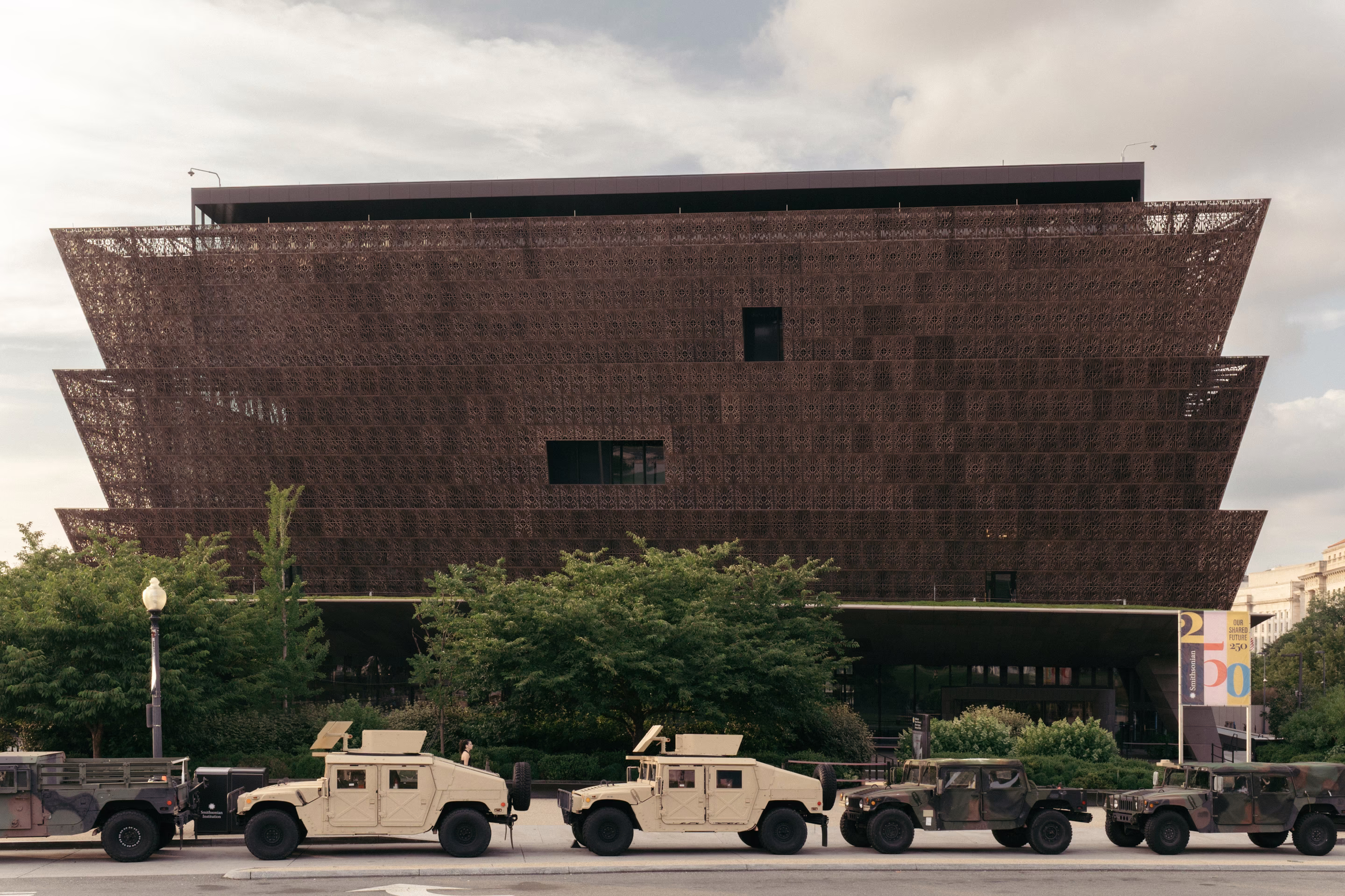 armed vehicles sit in a line outside of the National Museum of African American History and Culture