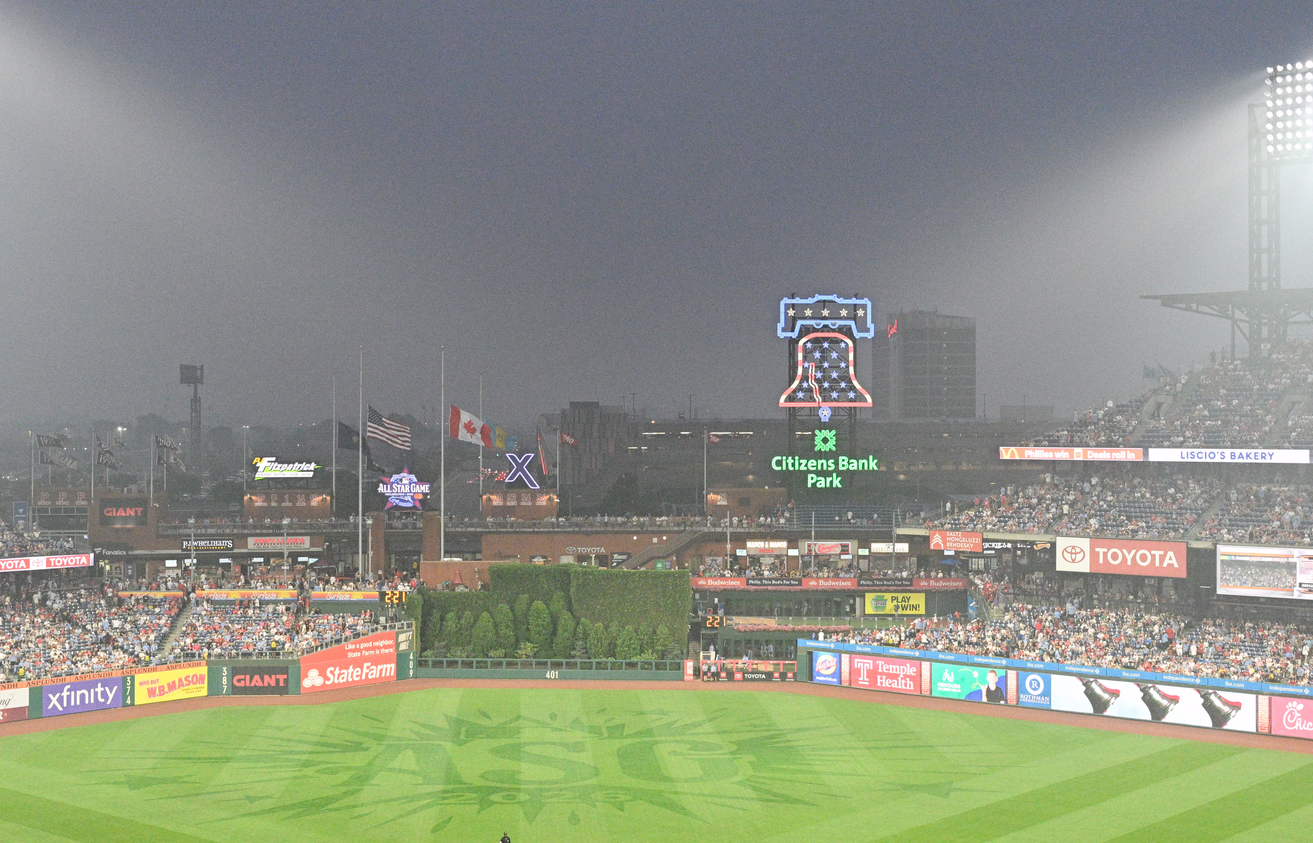 Wildfire smoke fills the air as fans in a baseball stadium watch a game.