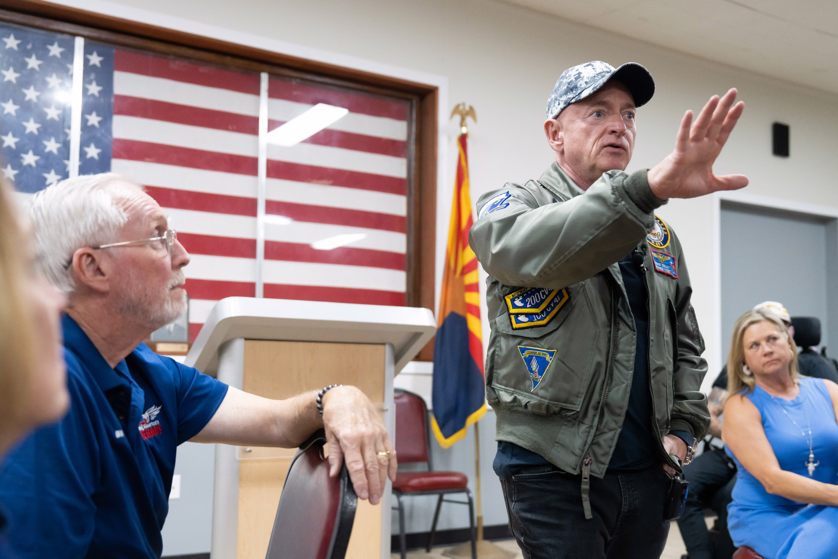 a man talks to a crowd with his arm raised up
