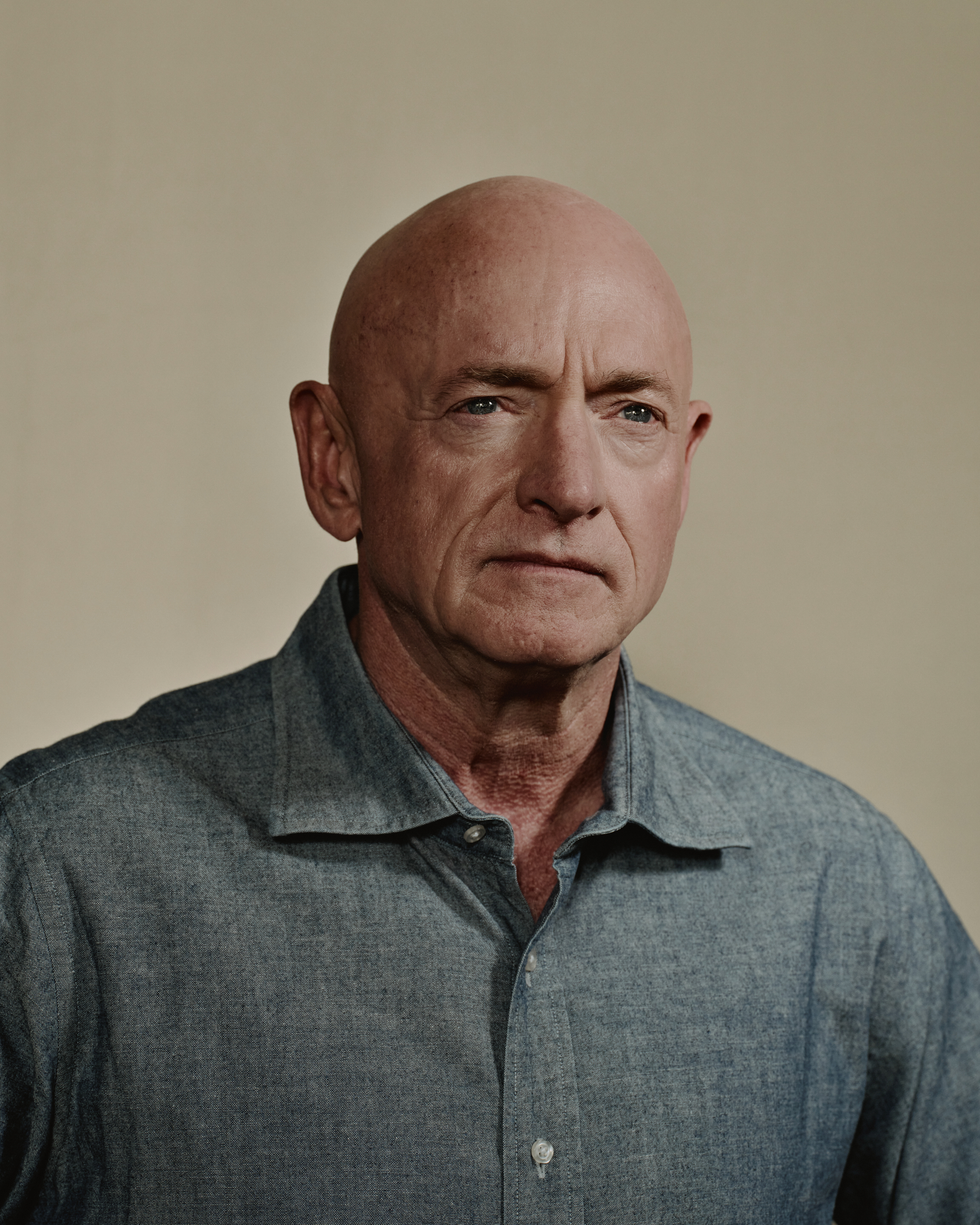 Mark Kelly in front of a tan backdrop