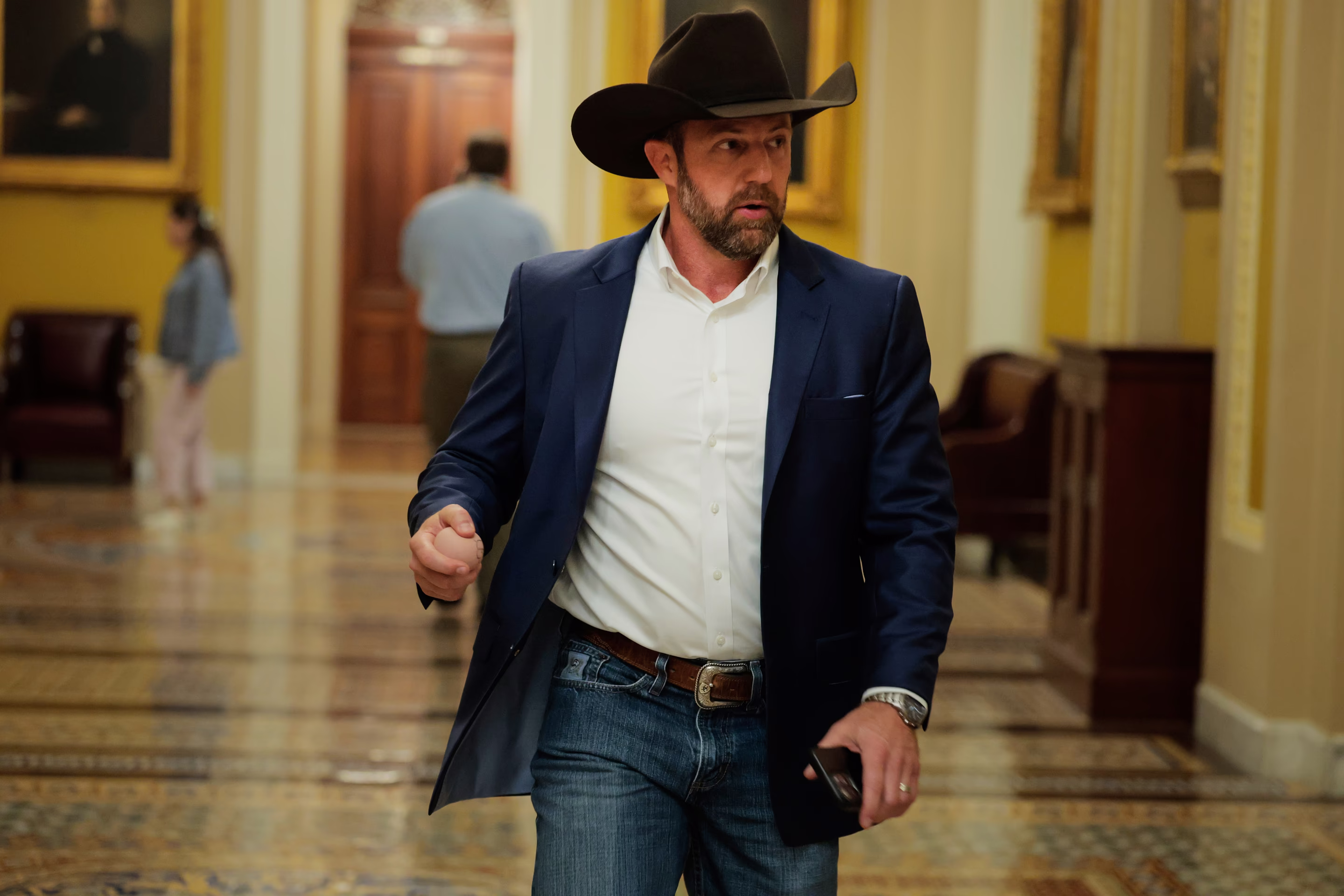 a man with a cowboy hat on walks