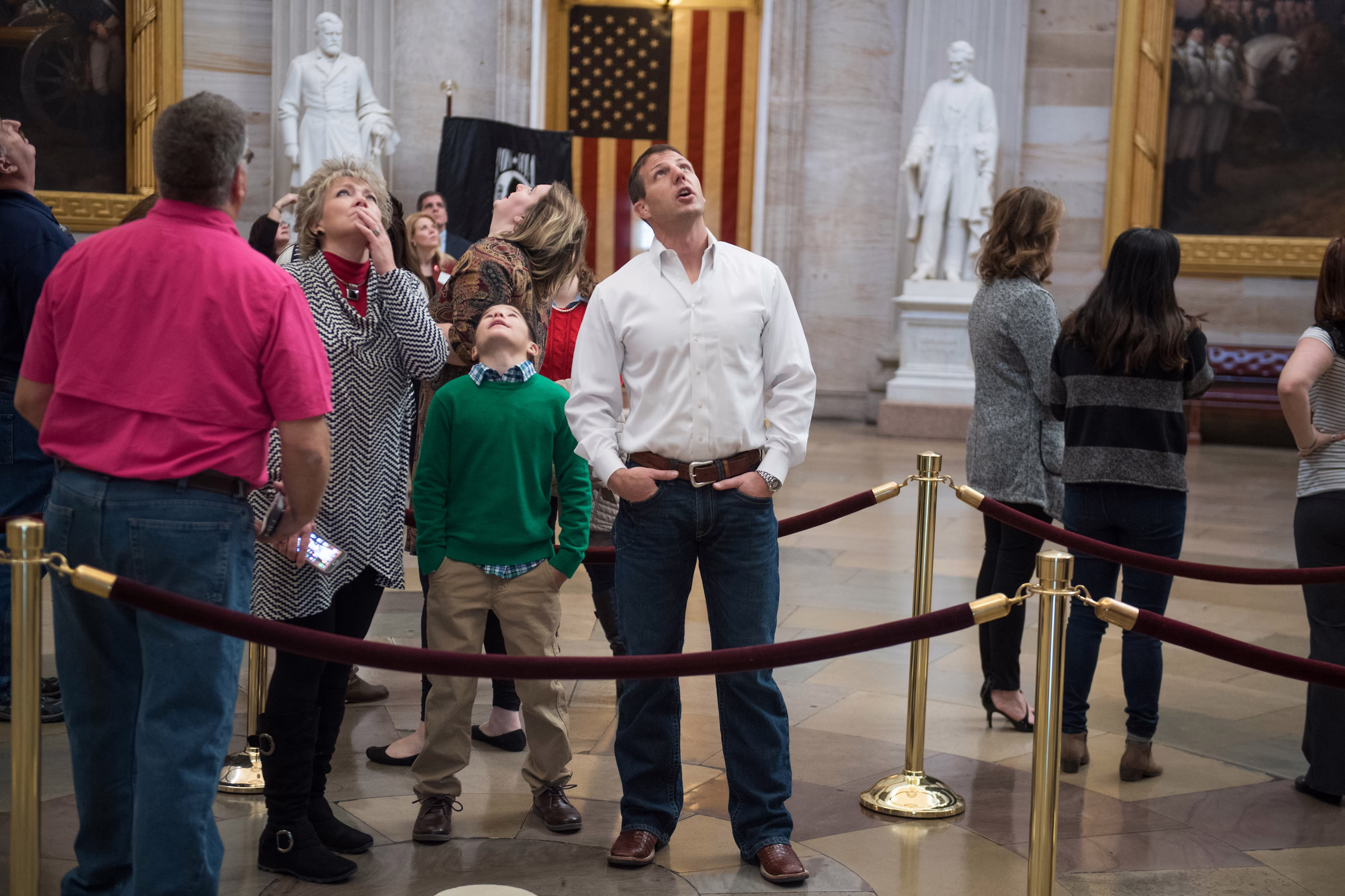 a man looks up alongside a child and a woman