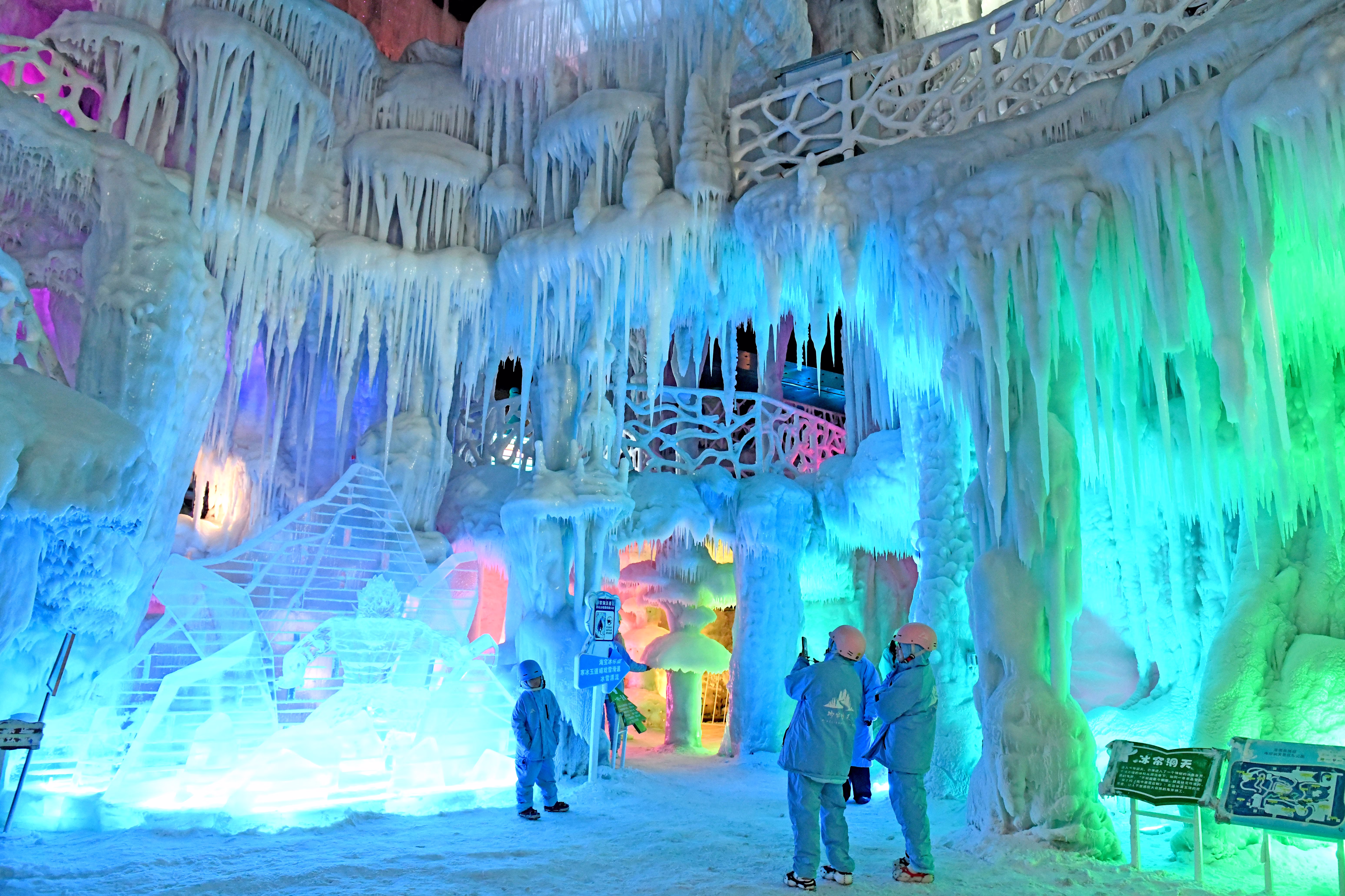 Several tourists take pictures inside an artificial ice cave.