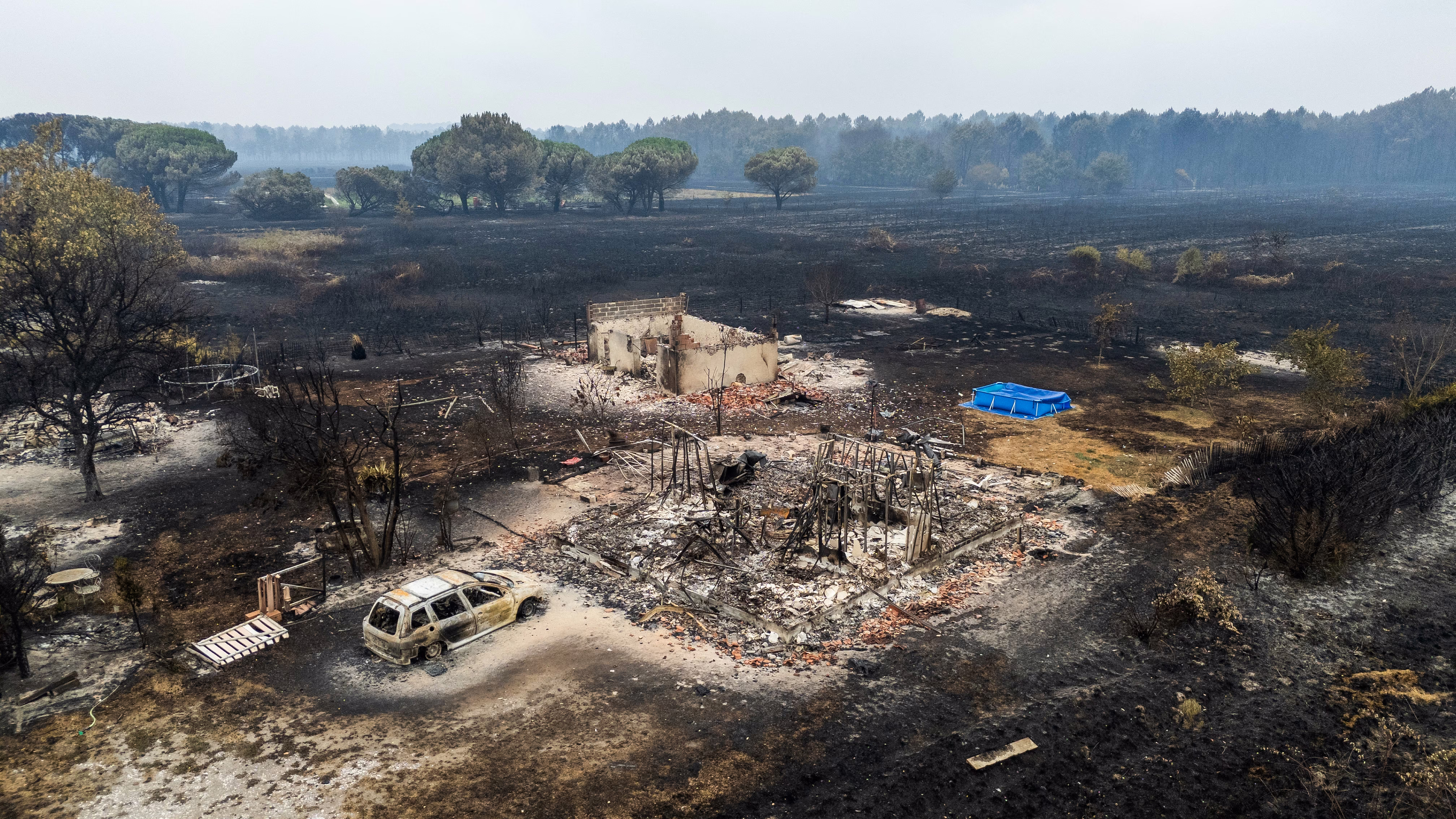 An aerial view shows a burned residential area following a wildfire.