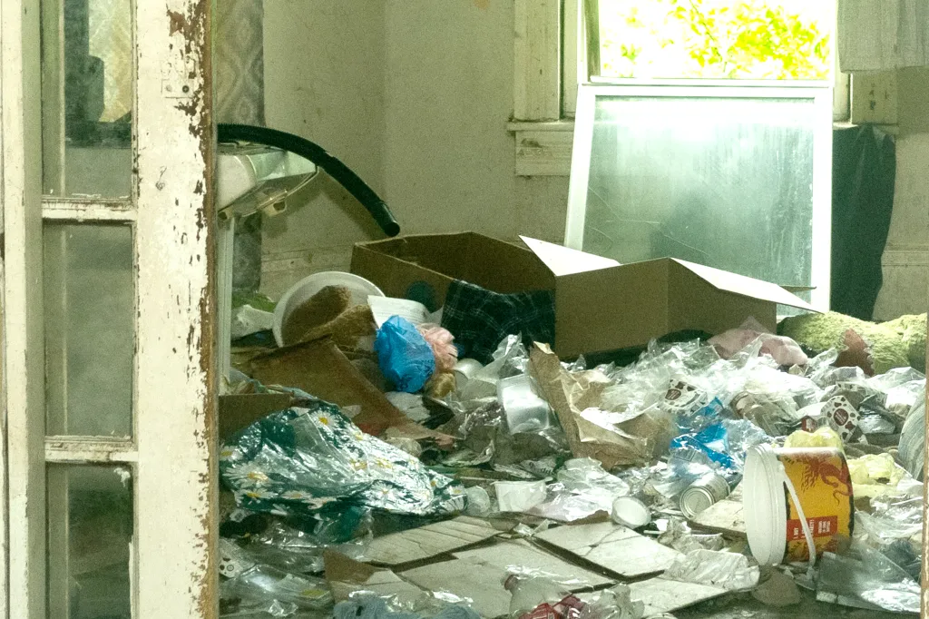 An interior view of a room in the Sider's home filled with trash and debris.