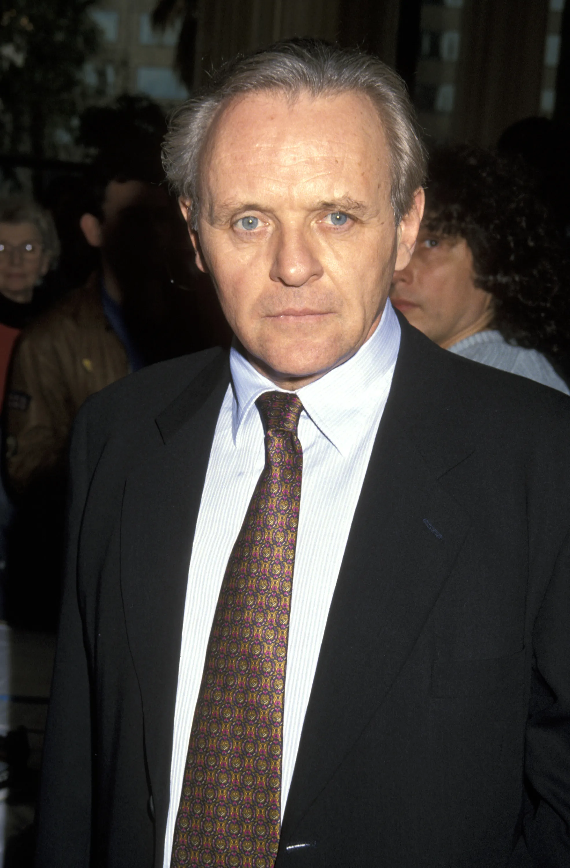 Anthony Hopkins wearing a black suit and a patterned tie.