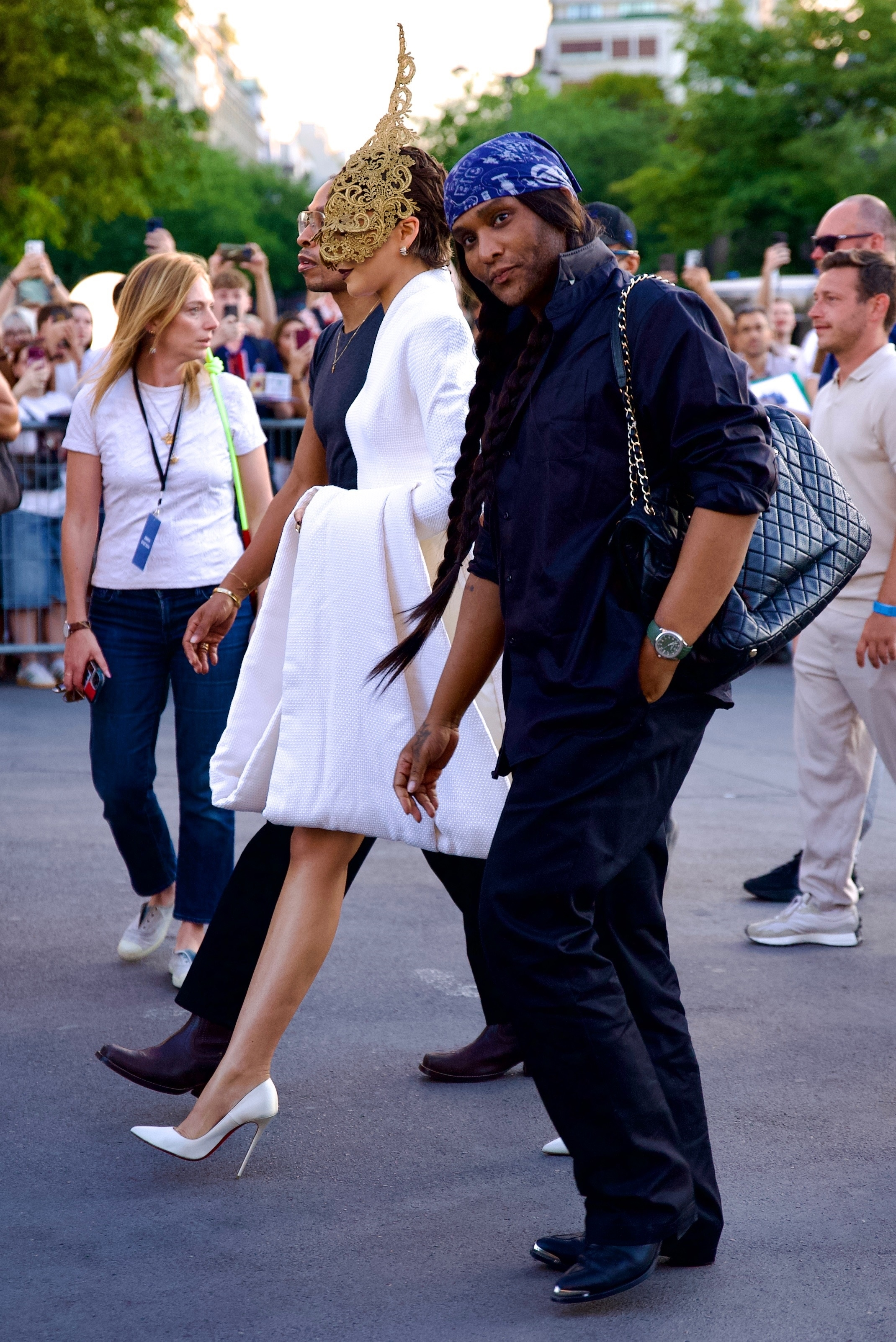 Zendaya wearing a white Givenchy dress and Alexander McQueen headpiece, accompanied by Law Roach at The Odyssey event in Paris.