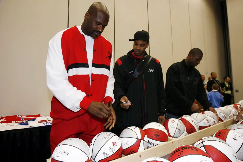 Shaquille O'Neal, Vince Carter, and Dwyane Wade signing basketballs during the 2006 East All-Star Team Practice.