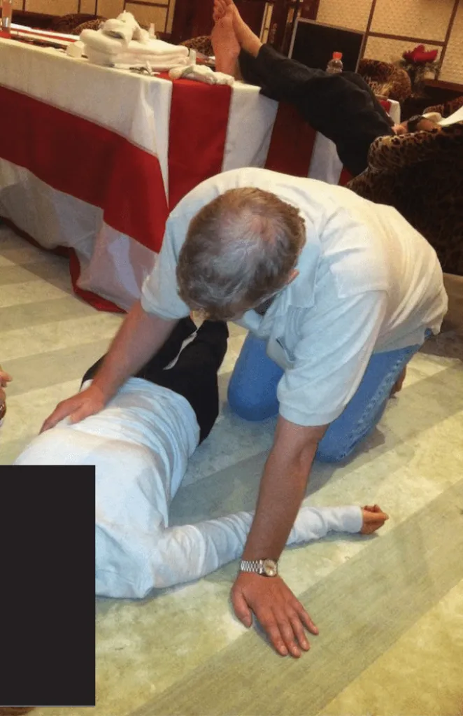 A man identified as Prince Andrew kneeling over a woman lying on the floor.