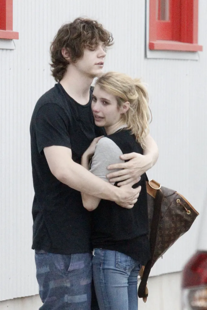 Emma Roberts is comforted by Evan Peters, who is hugging her, while she cries.