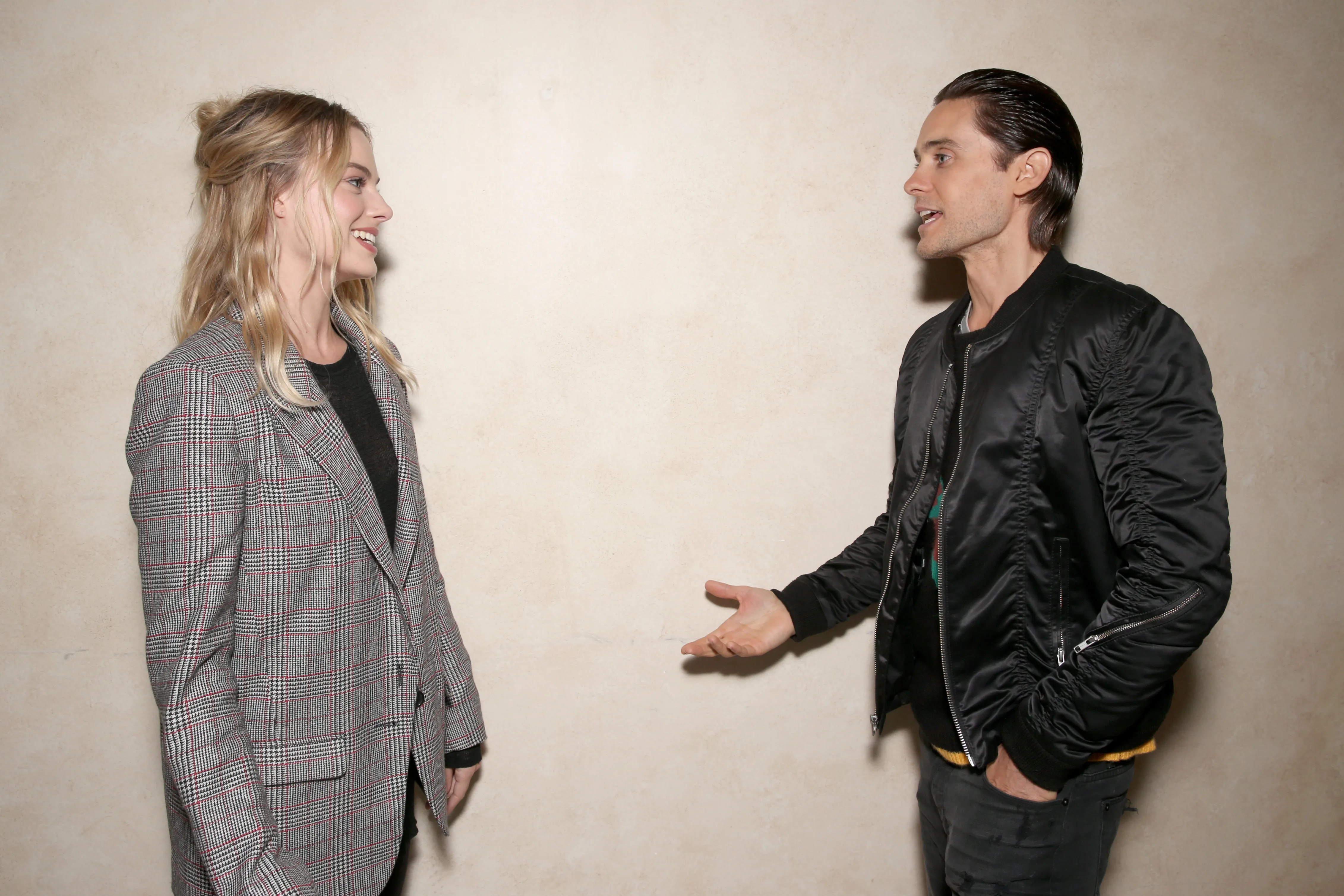Margot Robbie and Jared Leto smiling at each other at CinemaCon 2016.