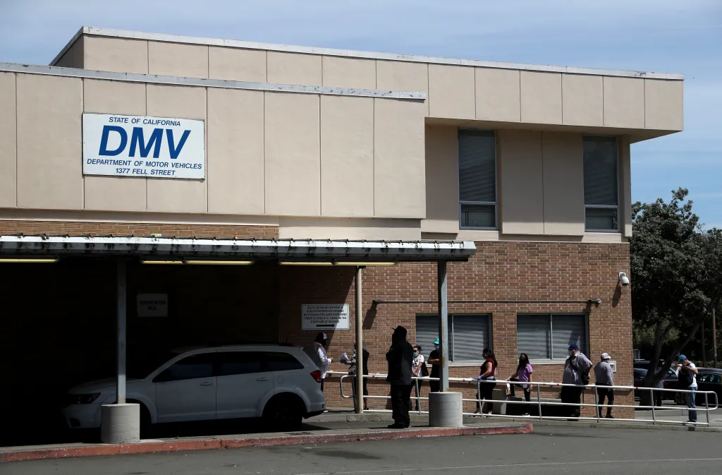 People waiting in line outside a California Department of Motor Vehicles (DMV) office.