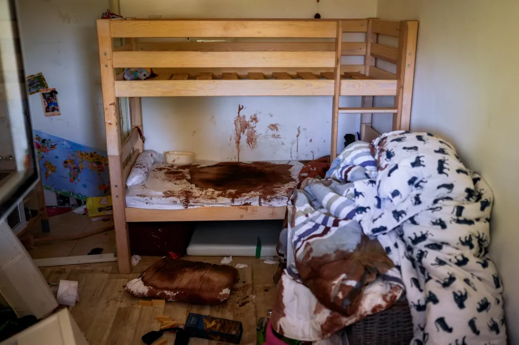 A child's room with a bunk bed, mattress, blankets, and walls splattered with blood.