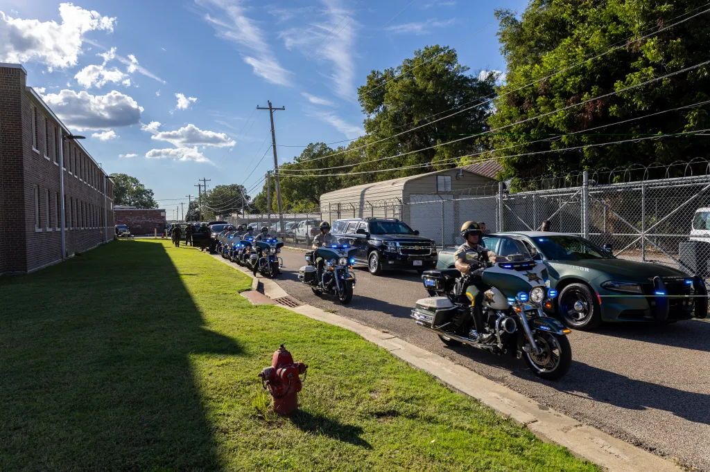 A motorcade of Tennessee State troopers, Shelby County Sheriff's deputies, and black SUVs escorting US Attorney General Pam Bondi, Secretary of War Pete Hegseth, and White House Deputy Chief of Staff Stephen Miller.