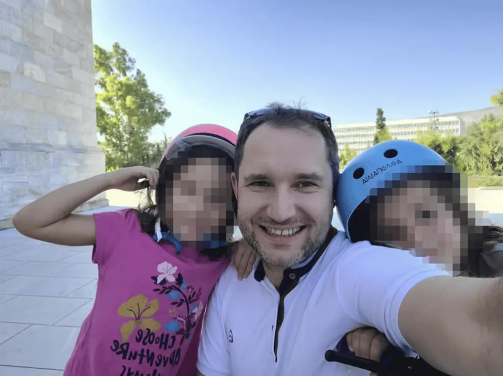 Przemek Jeziorski posing for a selfie with his two young children, all smiling and wearing helmets.