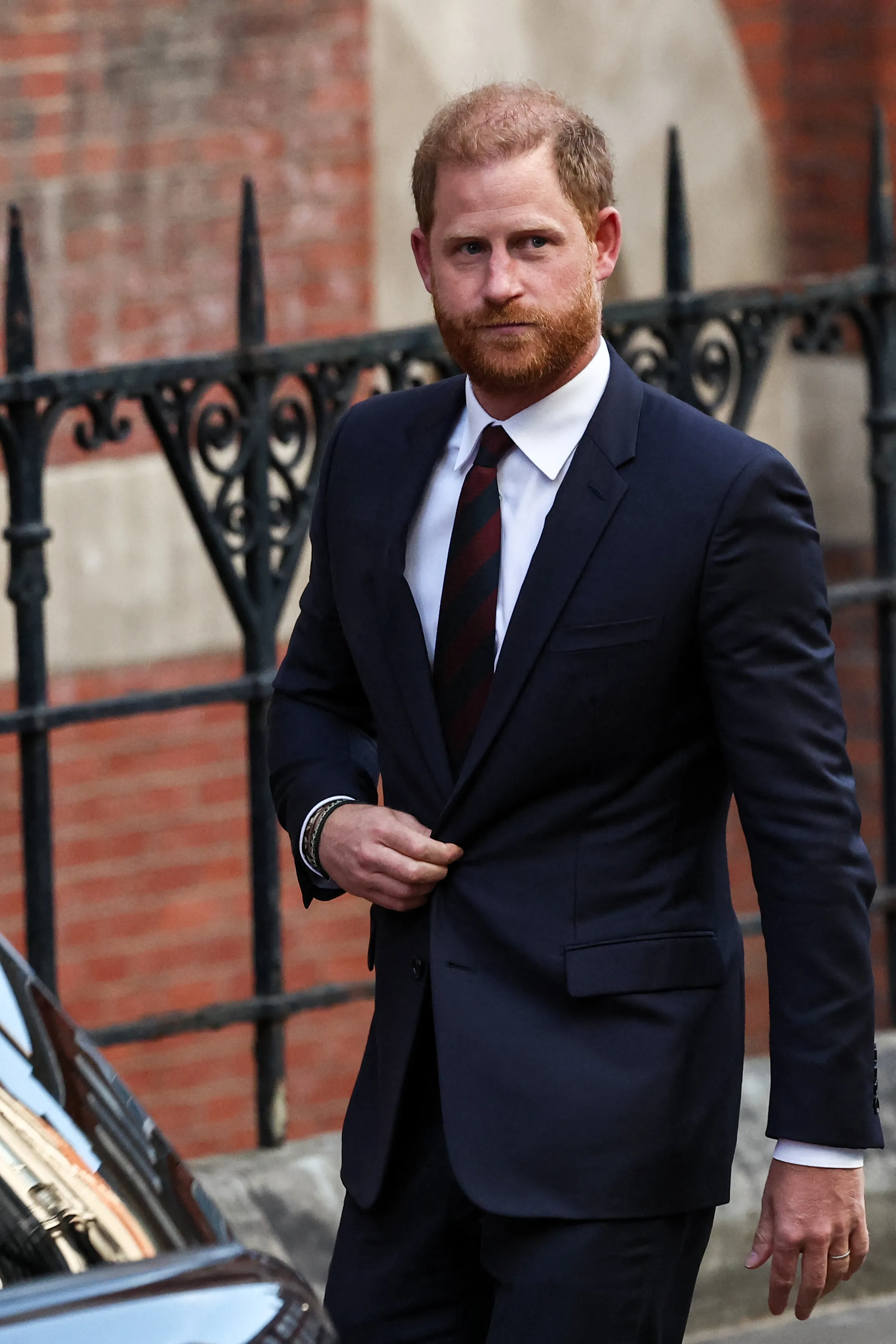 Prince Harry in a navy suit and striped tie.