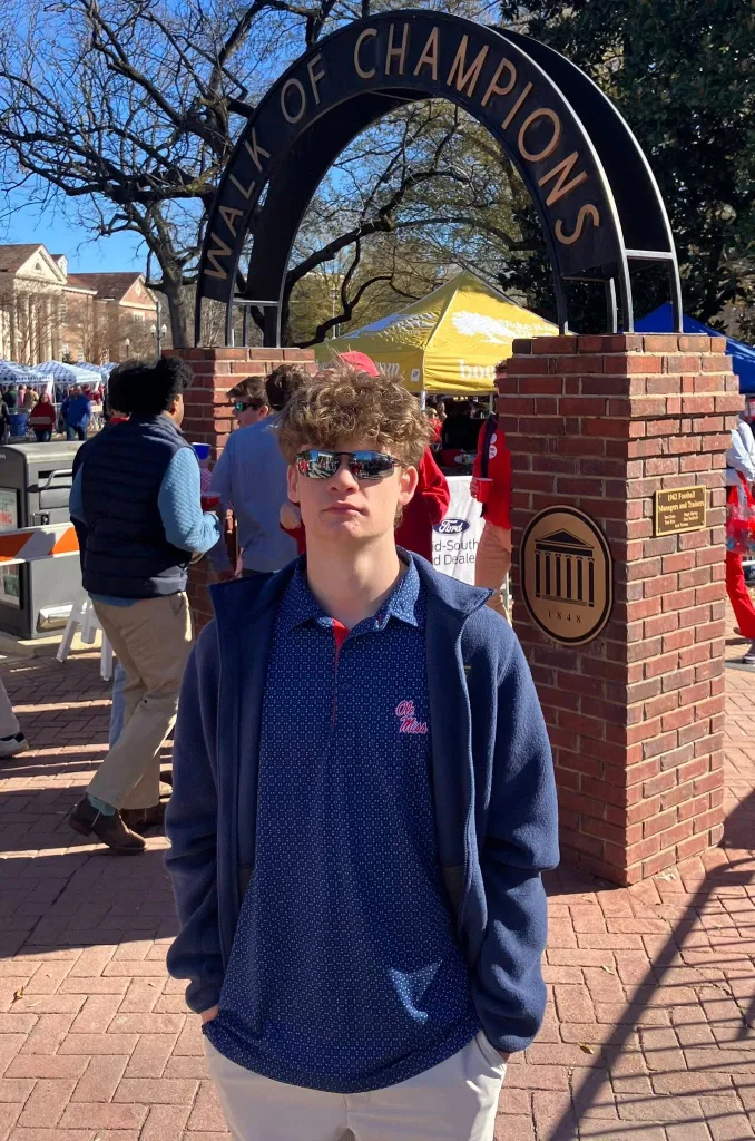 Brandon Baker standing in front of the "Walk of Champions" arch.