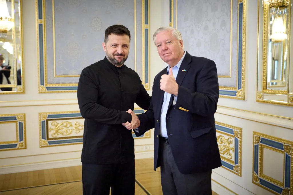 Ukraine's President Zelenskiy shakes hands with U.S. Senator Lindsey Graham.