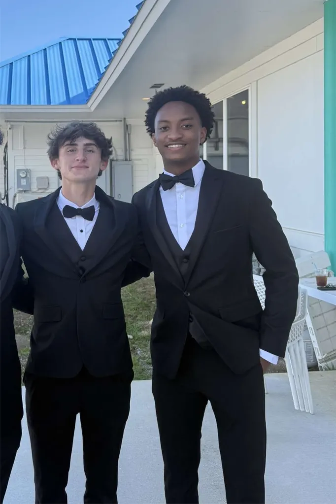 Warren Hudson and Nolan Wells posing in black tuxedos.