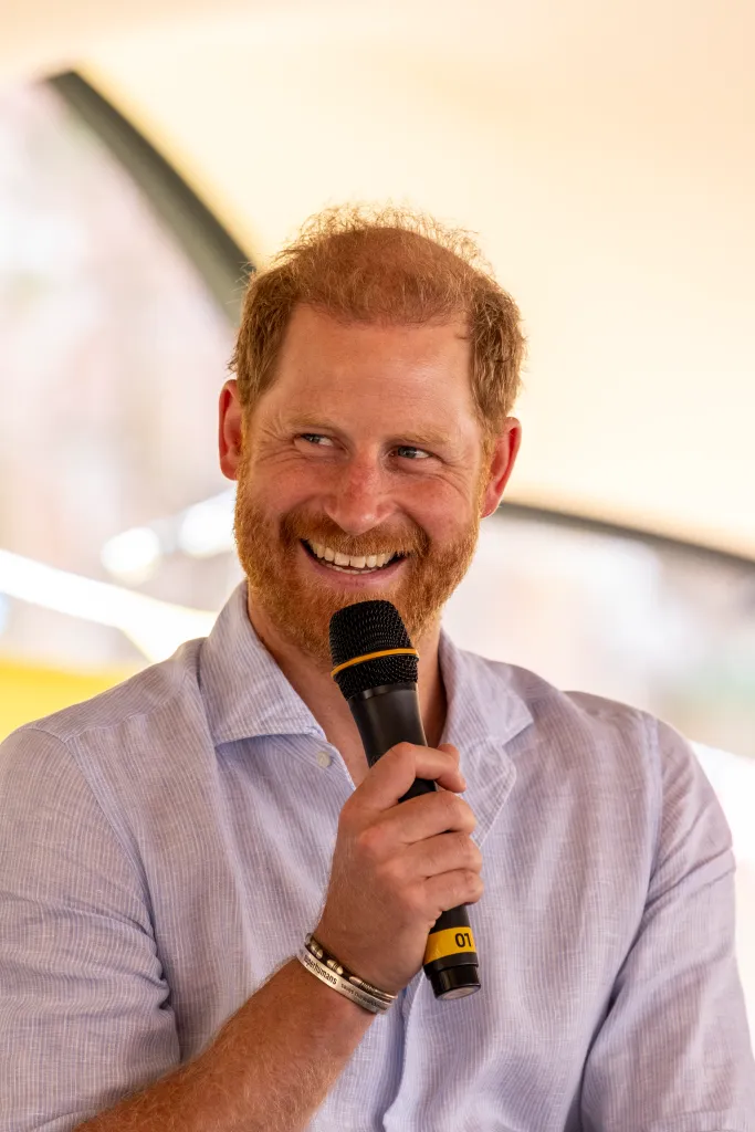 Prince Harry, Duke of Sussex, smiling while holding a microphone at Scotty's Summer Festival.