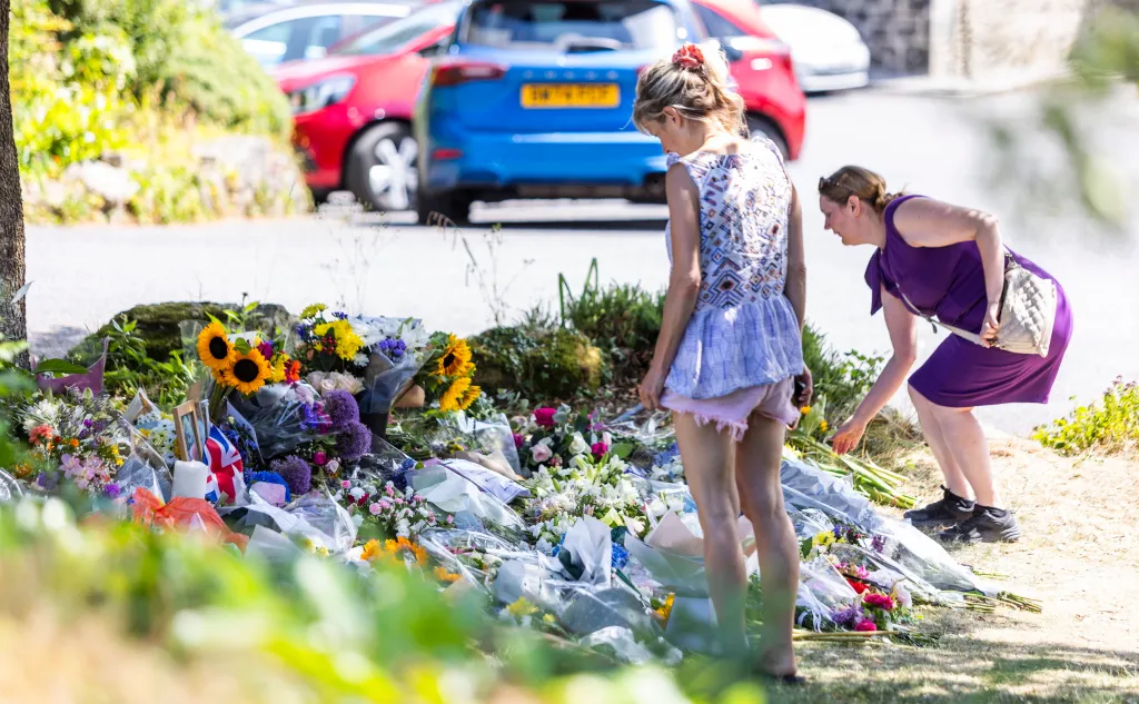People place flowers at a memorial near Ann Widdecombe's home on July 14, 2026.