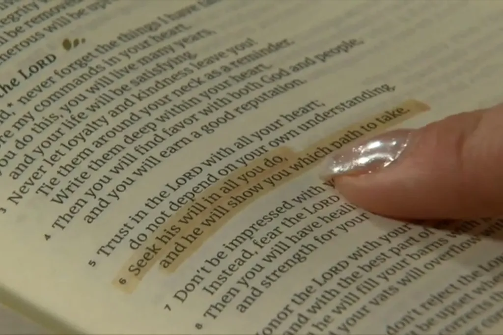 A finger points to Proverbs 3:6 in an open Bible.
