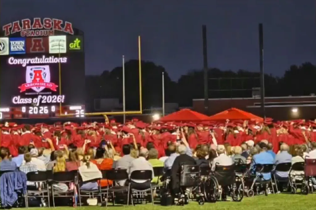 Graduation ceremony for the Class of 2026 at Taraska Stadium with students in red caps and gowns and an audience.