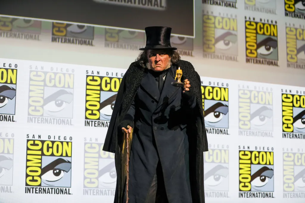 Actor Johnny Depp in "Ebenezer" costume holding a lit candle and a cane at San Diego Comic-Con.