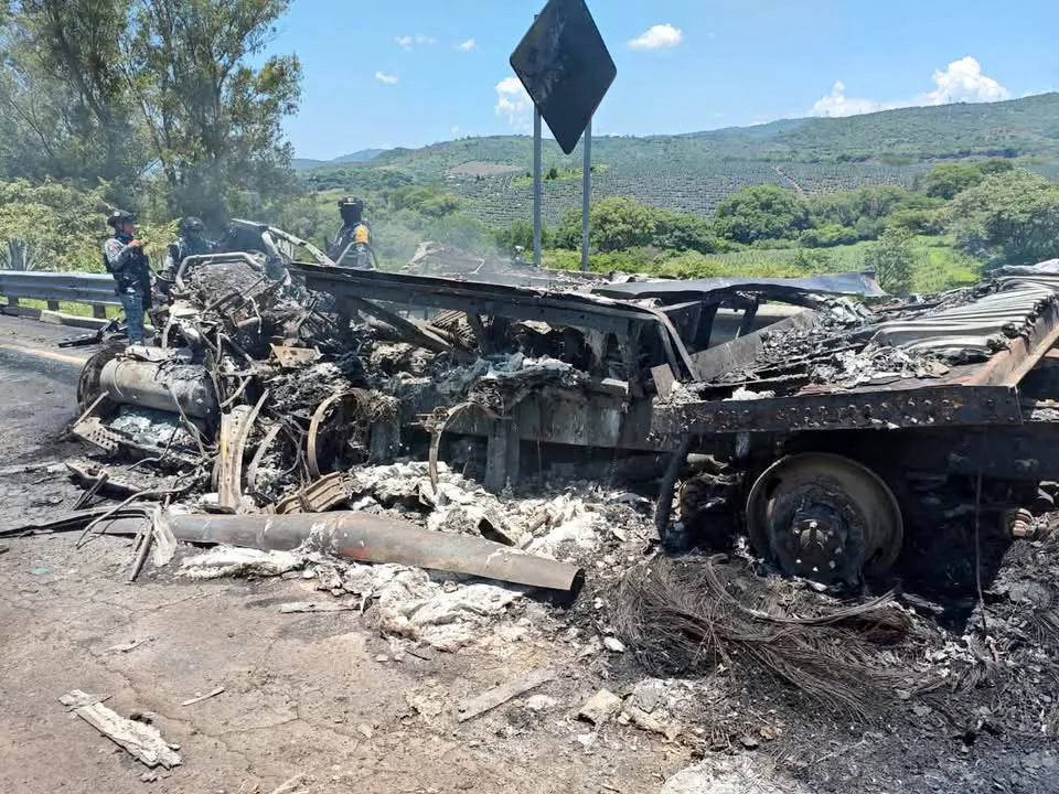 Mexican authorities inspect the incinerated frame of a tractor-trailer on a highway connecting Guadalajara and Tepic in Jalisco, Mexico, on Sunday.