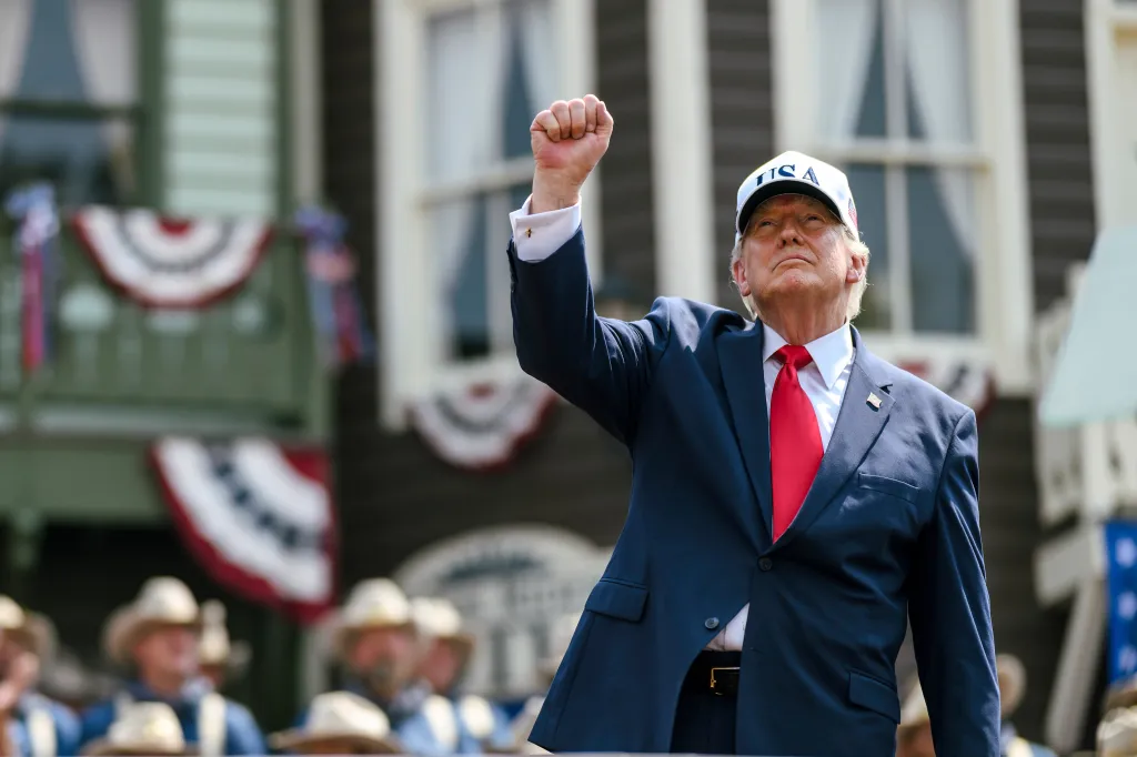 President Donald Trump with his fist raised at the Theodore Roosevelt Presidential Library opening.