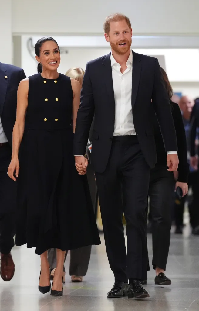 Meghan, Duchess of Sussex and Prince Harry, Duke of Sussex hold hands while walking through the Royal Children's Hospital in Melbourne, Australia.