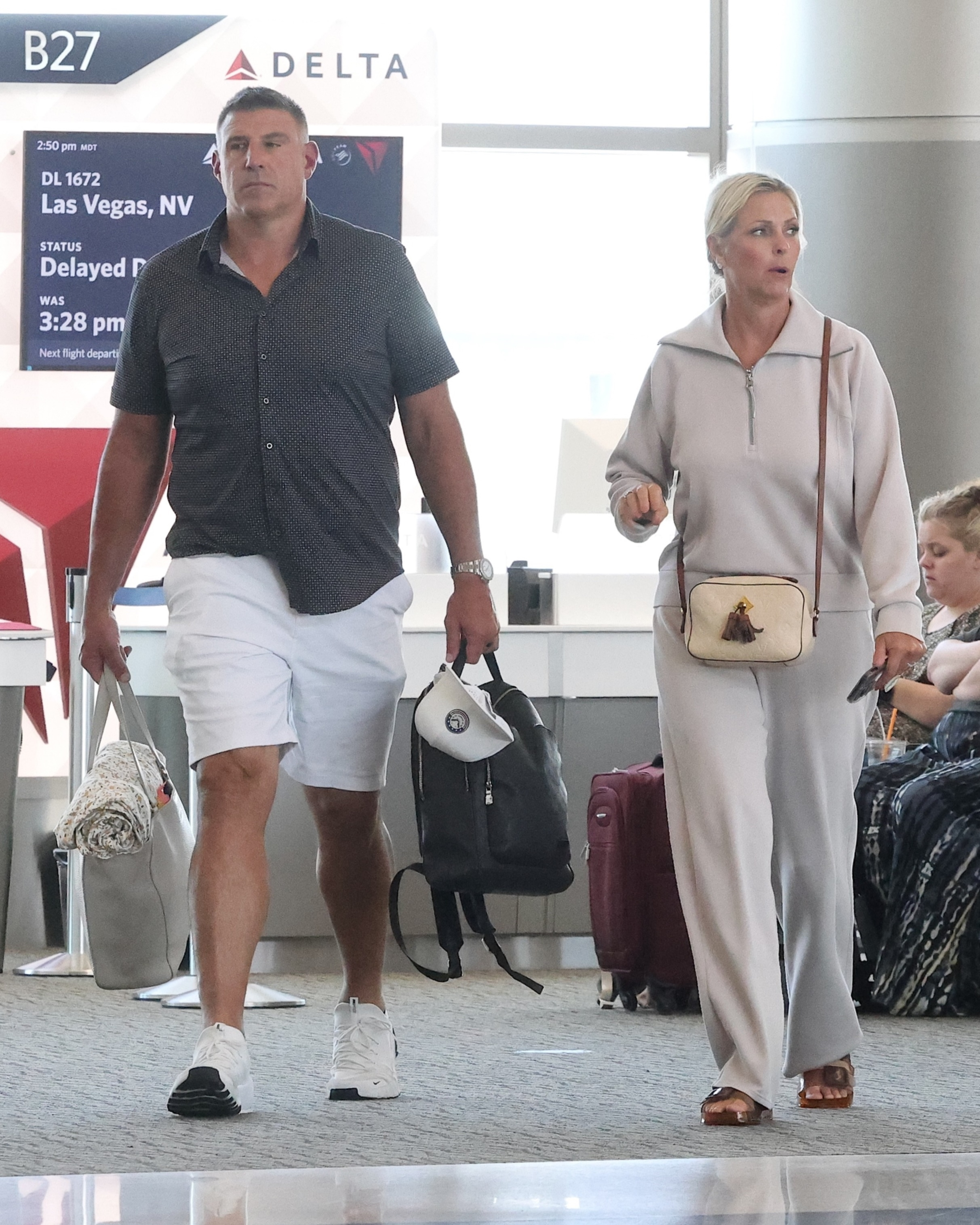 Mike Vrabel and Jennifer Vrabel walking through Salt Lake City airport.