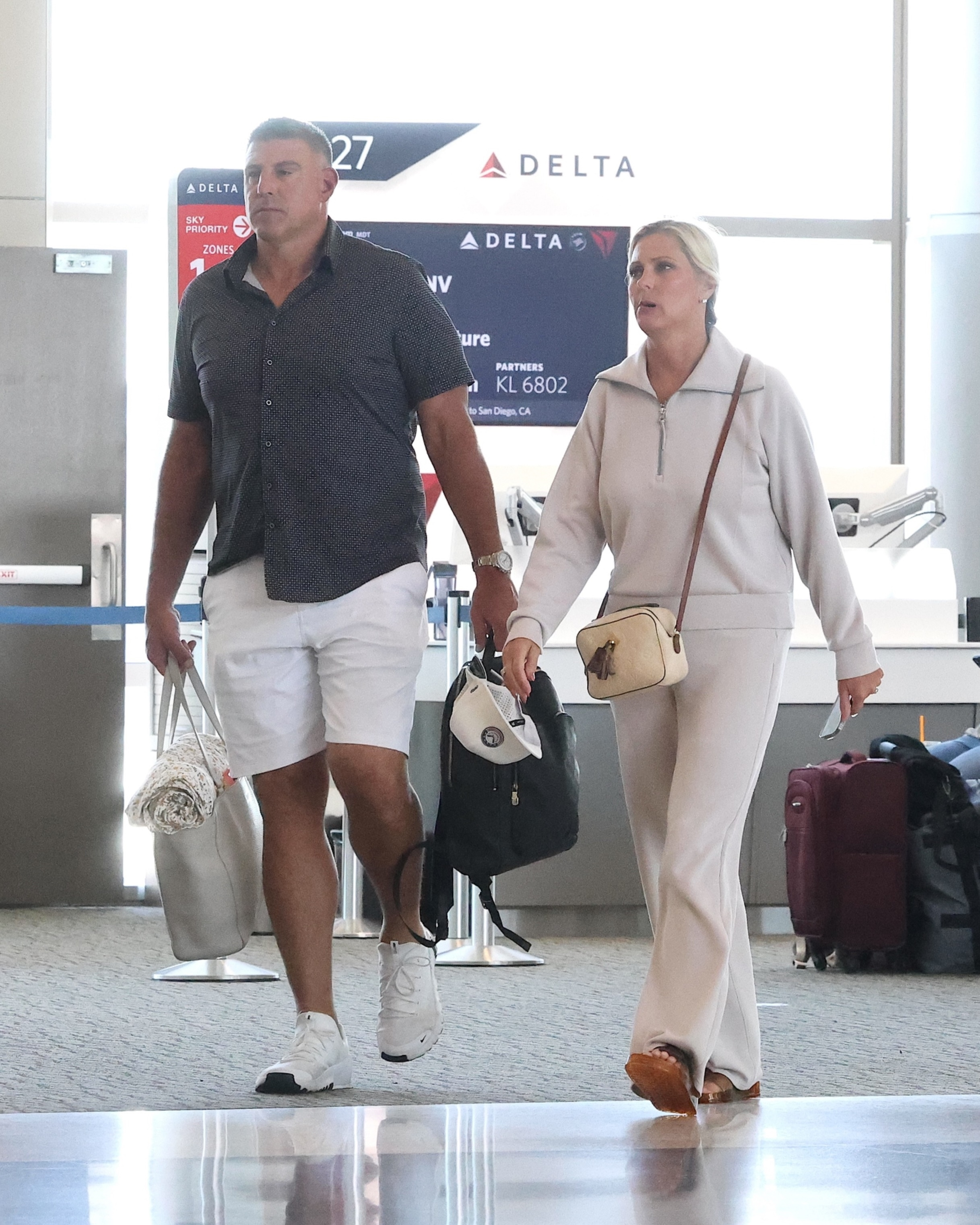 Mike Vrabel and Jennifer Vrabel walk through Salt Lake City airport.