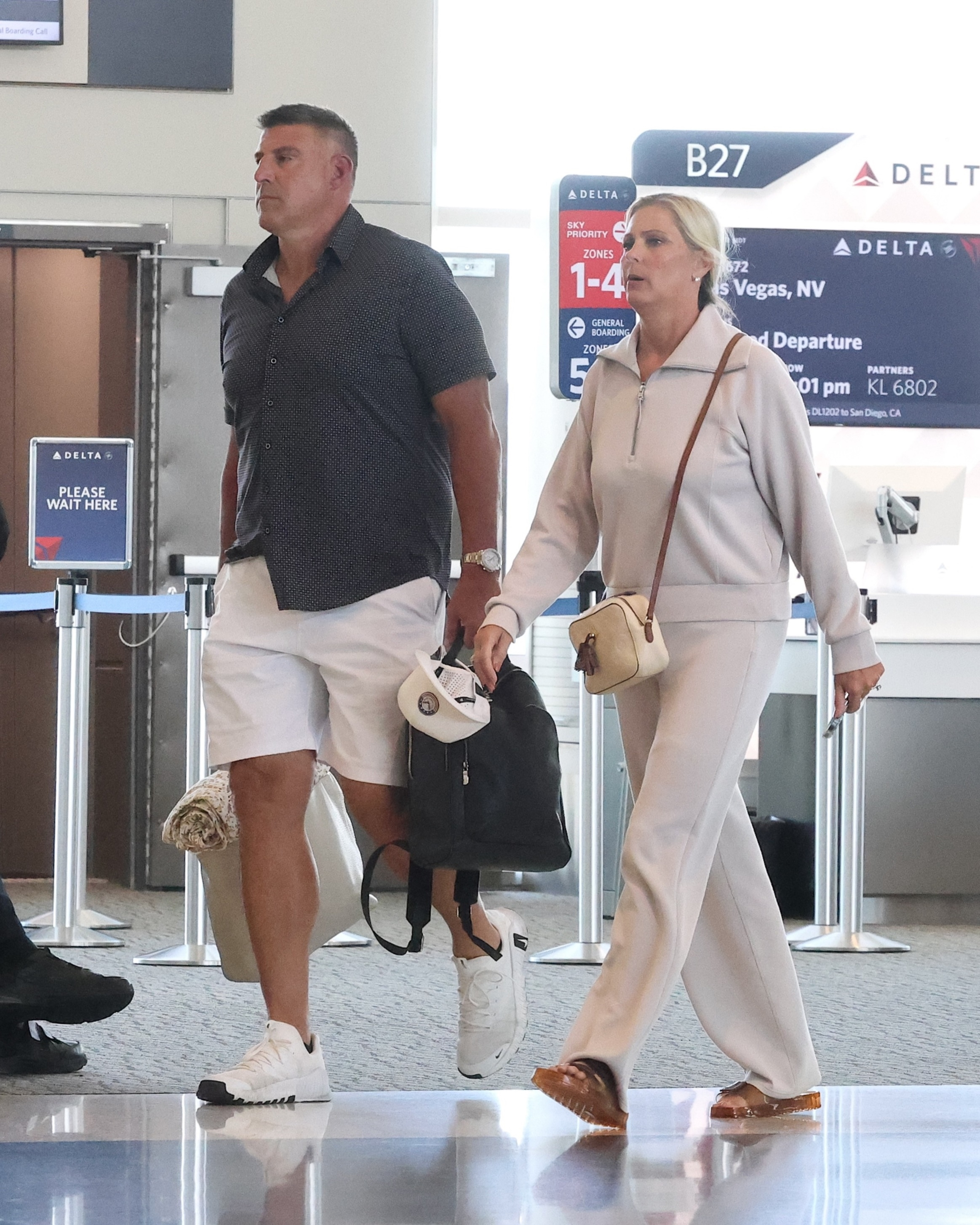 Mike Vrabel and wife Jennifer walking through the airport.