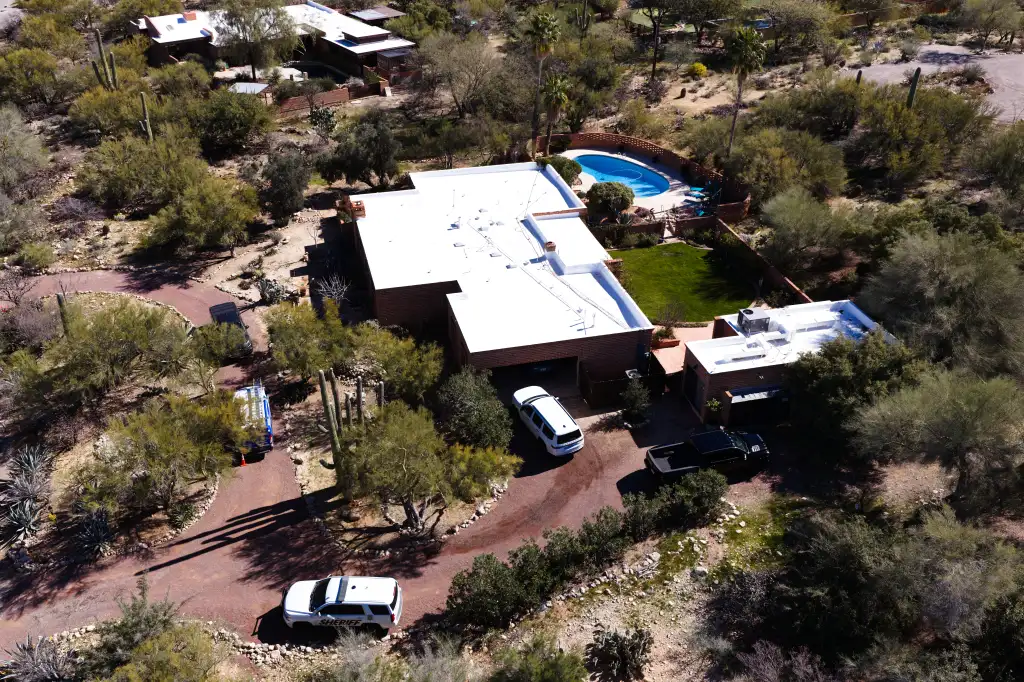 Aerial view of Nancy Guthrie’s residence with a white sheriff's SUV and other vehicles parked on the property's driveway.