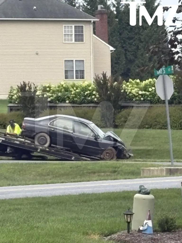 A damaged black car being loaded onto a tow truck.