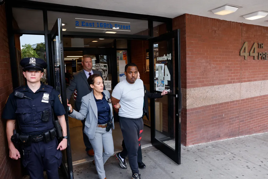 William Ferrer being escorted by detectives out of the 44th Precinct.