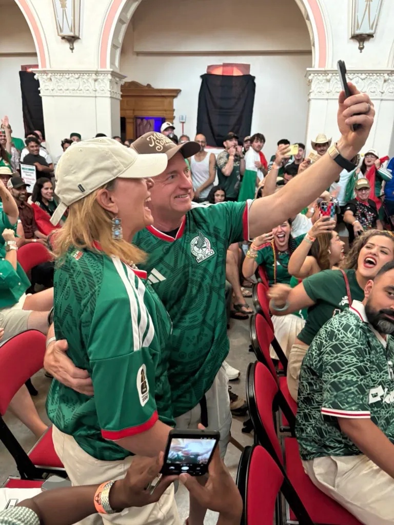 Mark Kelly and Gabby Giffords in Mexico jerseys taking a selfie at a World Cup watch party.