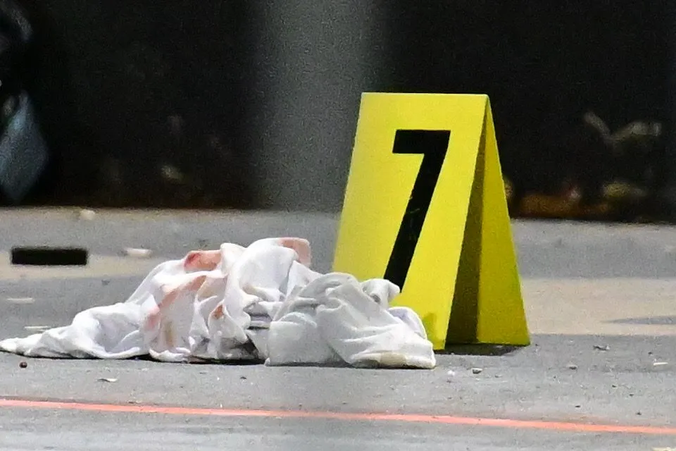 Bloody t-shirt next to evidence marker 7 at a crime scene.