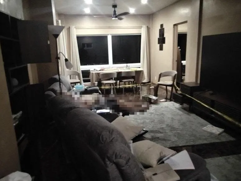 Crime scene with a body covered by an object in the living room.